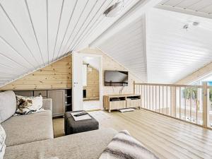 a living room with a couch and a tv at Holiday home Fall in Raufoss