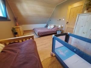 a room with a bedroom with a bed and a crib at CHALUPY TRI GROŠE VLAŠKY in Bešeňová