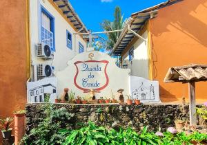um sinal para um edifício com estatuetas na parede em Pousada Quinta Do Conde em Tiradentes