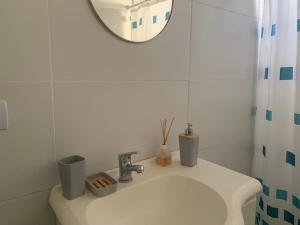W białej łazience znajduje się umywalka i lustro. w obiekcie PataGo! Sea&Sand w mieście Playa Unión