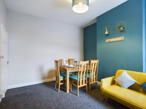 a dining room with a table and chairs and a couch at Pottery House - Stoke on Trent -Free parking - Central Location - Sleep 8 in Stoke on Trent
