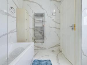 een witte badkamer met een bad en een douche bij Stoke On Trent - City Centre, Ideal for contractors, families, and business travelers By Doko Homes in Stoke on Trent