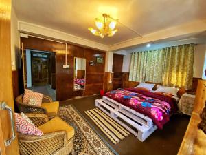 a bedroom with a large bed and a couch and chairs at Mountain Hideaway in Darjeeling