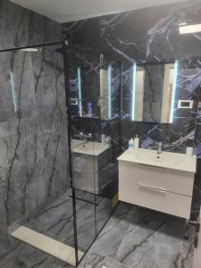 a bathroom with a sink and a mirror at Apartament bloc nou - self check in - free parking in Craiova +15 photos