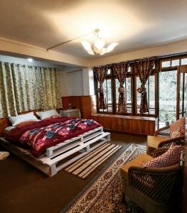 a bedroom with a large bed and some windows at Mountain Hideaway in Darjeeling