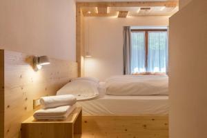 um quarto com uma cama e uma janela em Buffaure a parte em Pozza di Fassa