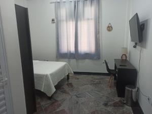 a bedroom with a bed and a window and a desk at Apto Centro SP ótima localização in Sao Paulo
