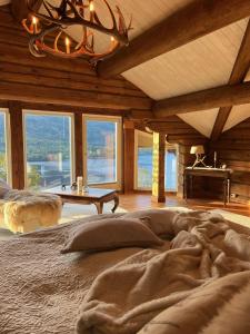 a bedroom with a large bed in a room with windows at "SoFly Lodge", Charm and Elegance in Noresund