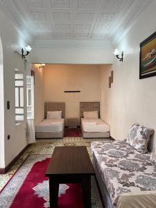 a living room with two beds and a coffee table at Riad Del Rey in Rabat