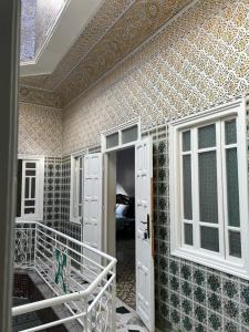 Habitación con puerta y pared con azulejos. en Riad Del Rey, en Rabat