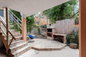 un patio con una chimenea de piedra y una silla azul en Casa Nicole - Near the Beach, en Geremèas