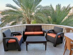 uma varanda com cadeiras e mesas e uma palmeira em BnB La Luna Entire Apartment em Jericó