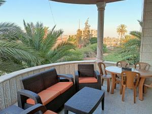 Un balcón con sillas, una mesa y una mesa con sillas. en BnB La Luna Entire Apartment en Jericho