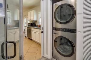 a kitchen with a washing machine and a washer at Dog-Friendly Vero Beach Retreat with Porch and Grill! in Vero Beach