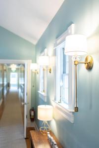 a hallway with three lights on the wall and a table at Biddle Point Inn in Plymouth
