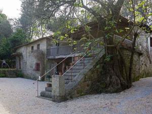a stone building with stairs next to a tree at Quinta do Galgo in Amares