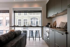 a living room with a couch and a kitchen at Margriet Apart-Suites in Ghent