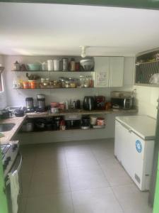 a kitchen with a counter and shelves with pots and pans at Enjoy Hostel e Pousada in Aracaju