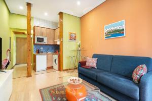 uma sala de estar com um sofá azul e uma cozinha em Victor Apartments Chueca II em Madri