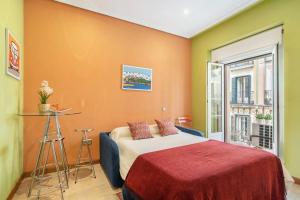 um quarto com uma cama com uma parede laranja em Victor Apartments Chueca II em Madri