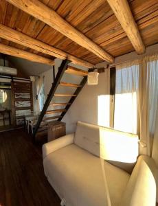 sala de estar con sofá y ventana en Tiny House - Chacras de Coria by Inside en Luján de Cuyo
