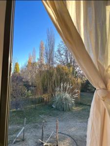 een raam met uitzicht op een tuin bij Tiny House - Chacras de Coria by Inside in Ciudad Lujan de Cuyo