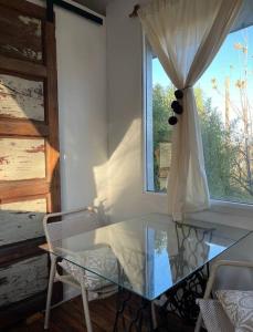 een glazen tafel en stoelen in een kamer met een raam bij Tiny House - Chacras de Coria by Inside in Ciudad Lujan de Cuyo