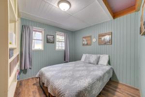 Cozy Otsego Lake Cabin Steps to Sandy Beach! في غايلورد: غرفة نوم مع سرير والجدران الزرقاء
