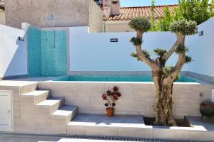 ein Pool mit zwei Bäumen und Treppen neben einem Gebäude in der Unterkunft Sítio DaTerra in Santo António da Terrugem