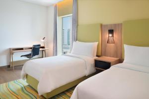 a hotel room with two beds and a desk and a window at Element by Westin City Center Doha in Doha