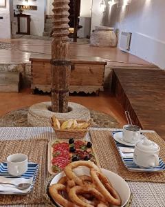 uma mesa com pretzels e um prato de anéis de cebola em Molino de Las Pilas - Ecoturismo - Caminito del Rey em Teba