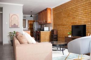 a living room with a couch and a brick wall at The Cosy Crib in Palatswe