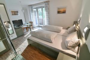 a room with a bed and a desk with a television at Luisenburg Resort in Wunsiedel