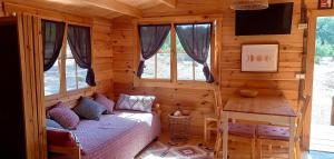 a bedroom with a bed in a log cabin at Quinta D' LuzArcoIris in Arganil