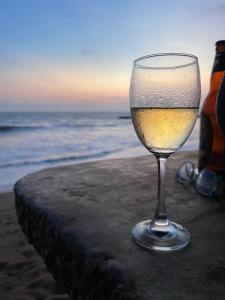 a glass of wine sitting on the beach at Hotel Coconut Bay in Kalutara
