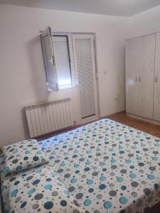 VILA LUKA في بودغوريتسا: غرفة نوم بسرير لحاف ازرق وبيض