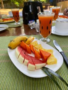 un piatto di frutta su un tavolo con una bevanda di Hotel Coconut Bay a Kalutara