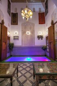 an indoor pool in a room with purple lighting at Dar Elinor in Fez