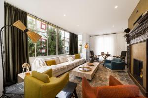 a living room with a white couch and chairs at Grand Hotel Soleil d'Or in Megève