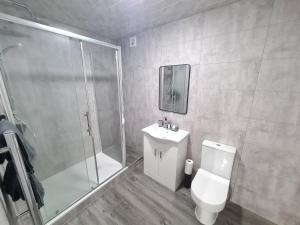 a bathroom with a shower and a toilet and a sink at Homestay by BIC Legends 4 in Batley Carr