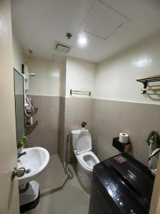 a bathroom with a toilet and a sink at Jay's Condo - Seawind in Davao City