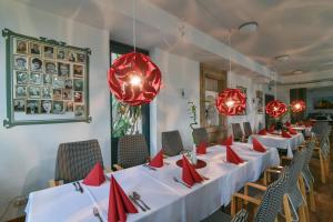 a row of tables in a restaurant with red chandeliers at Luisenburg Resort in Wunsiedel