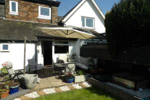 eine Terrasse mit einem Sonnenschirm und Stühlen in der Unterkunft Aigas in Glasgow