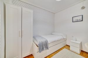 a small white bedroom with a bed and a closet at Las terrazas de Castañares by Clabao in Logroño