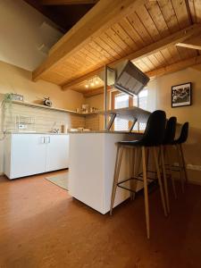 a kitchen with white cabinets and bar stools at Deti's Ferienwohnung in Andernach +12 photos