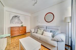 a living room with a couch and a mirror at Las terrazas de Castañares by Clabao in Logroño