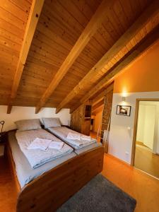 a large bed in a room with a wooden ceiling at Deti's Ferienwohnung in Andernach