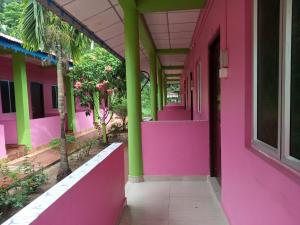 a pink and green building with a hallway at Dream Land Resort Havelock in Havelock Island