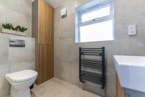 uma casa de banho com um WC, uma janela e um lavatório. em Charming Elegance at The Pontcanna Pearl - Prime Location with Comfort and Style em Cardiff
