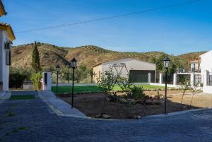 un patio con un aro de baloncesto y un edificio en La Masía casa rural junto al río, en Almedinilla